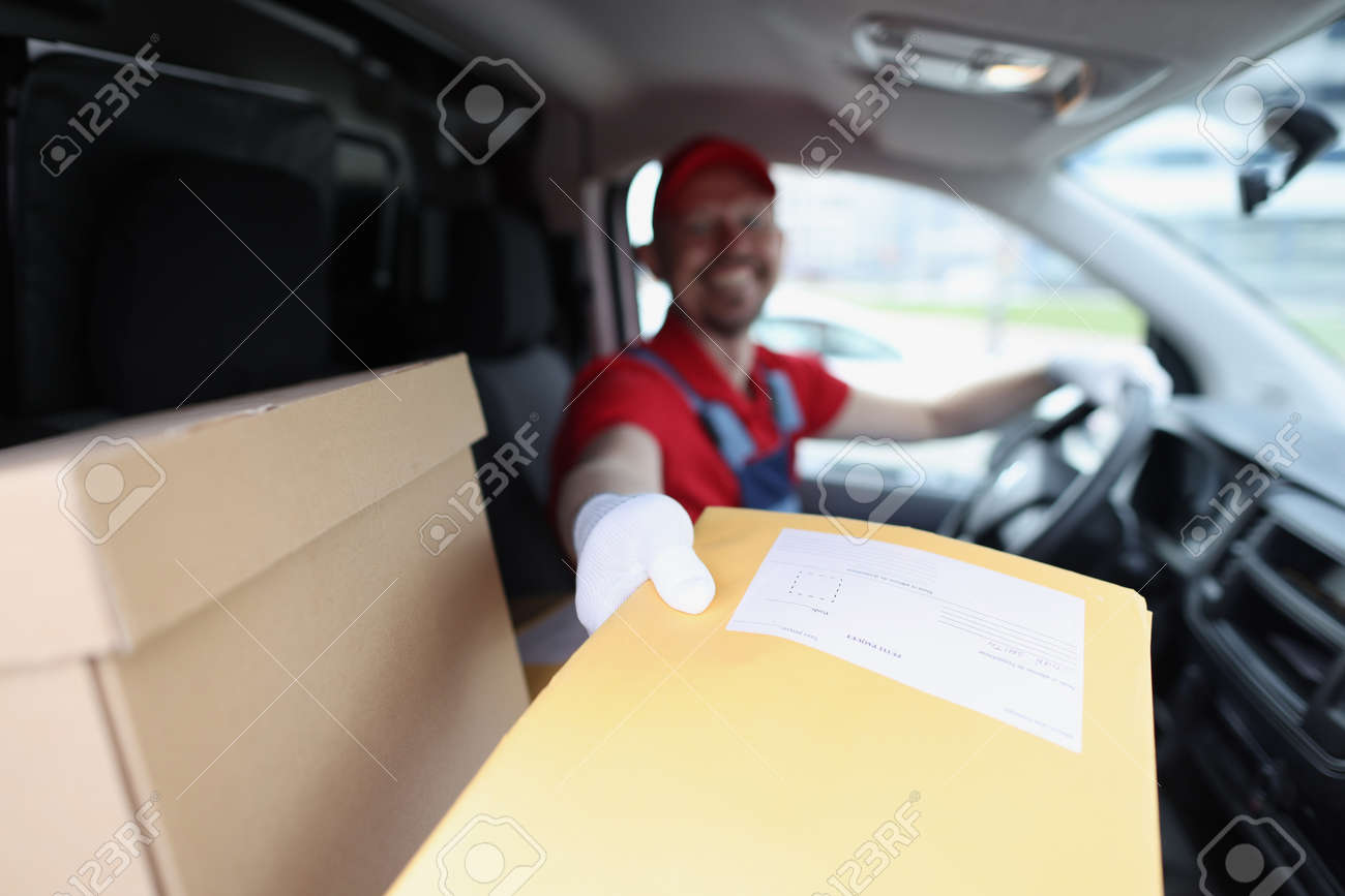 Man delivering yellow envelope from car closeup - 168469720 Man delivering yellow envelope from car closeup - 168469720