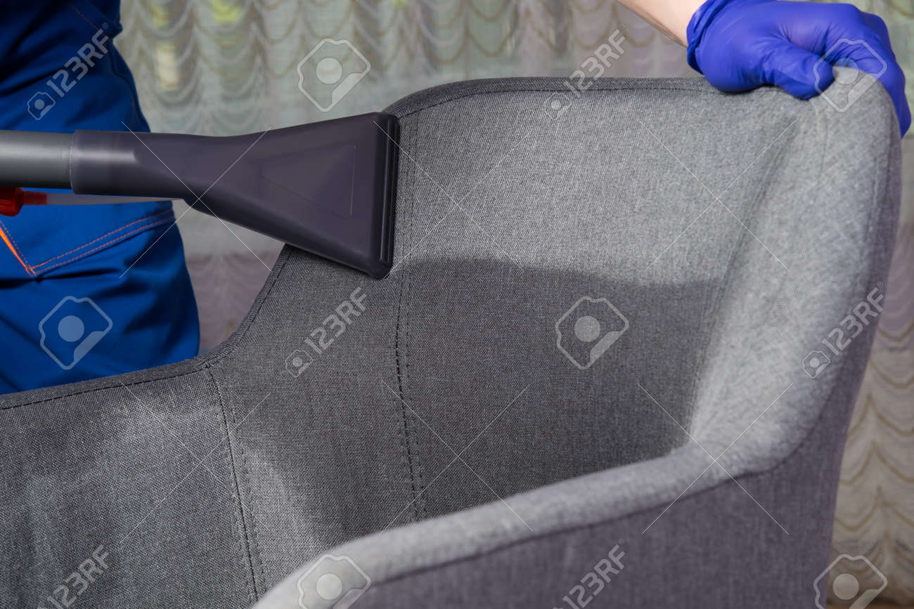 application of water with a cleaning solution for further cleaning of the gray chair, professional cleaning of upholstered furniture, large-scale plan - 169657047 application of water with a cleaning solution for further cleaning of the gray chair, professional cleaning of upholstered furniture, large-scale plan - 169657047
