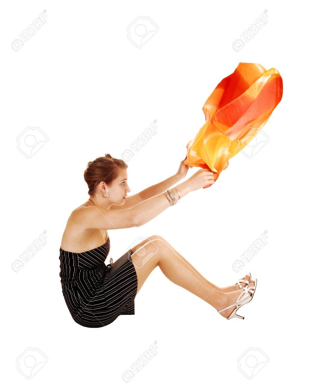 A Young Woman In A Black Striped Dress Sitting On The Floor And