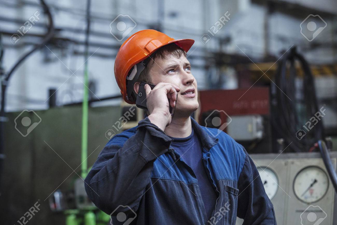 The young man working at the old factory on installation of equipment in a protective helmet - 40821854 The young man working at the old factory on installation of equipment in a protective helmet - 40821854