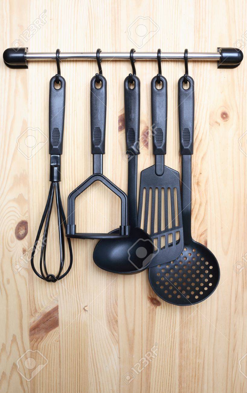 set of black modern kitchen utensil hanging on wooden background set of black modern kitchen utensil hanging on wooden background