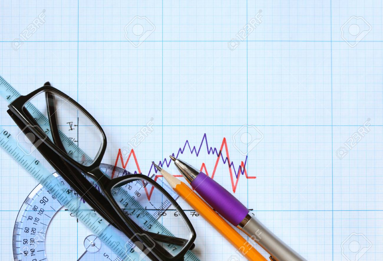 closeup of spectacles and office tools on graph paper with diagram office graph paper