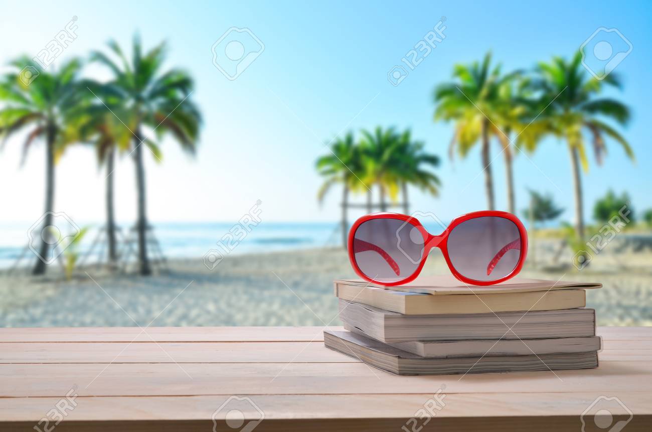海の景色の背景が付いている本のスタックの赤いサングラス の写真素材 画像素材 Image
