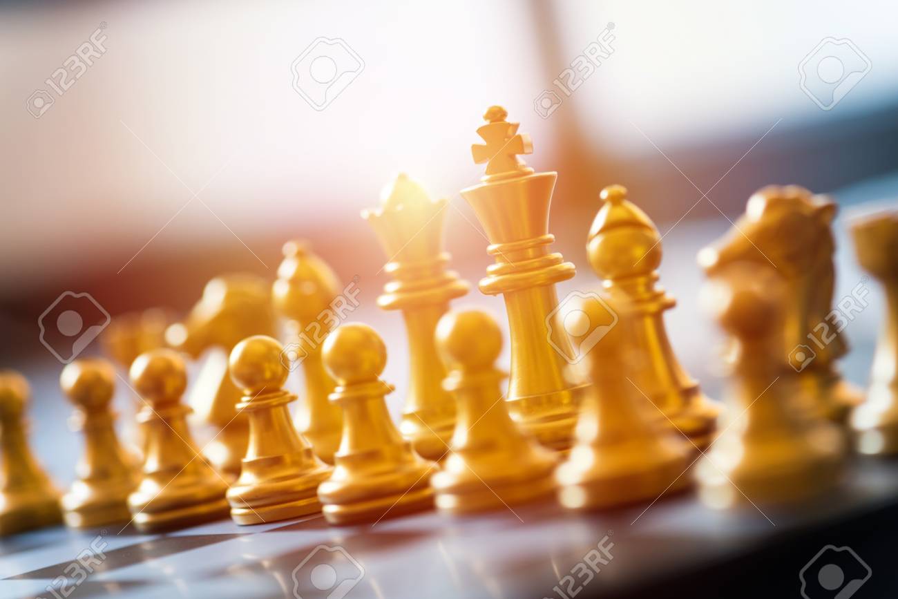 gold chess pieces on a chessboard business strategy concept stock
