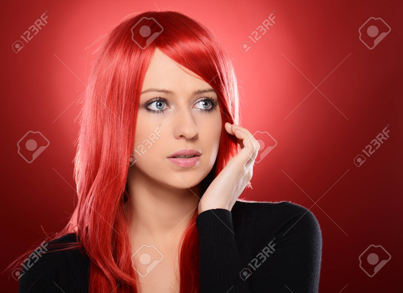 美しい赤髪女性が赤い背景にポーズ の写真素材 画像素材 Image
