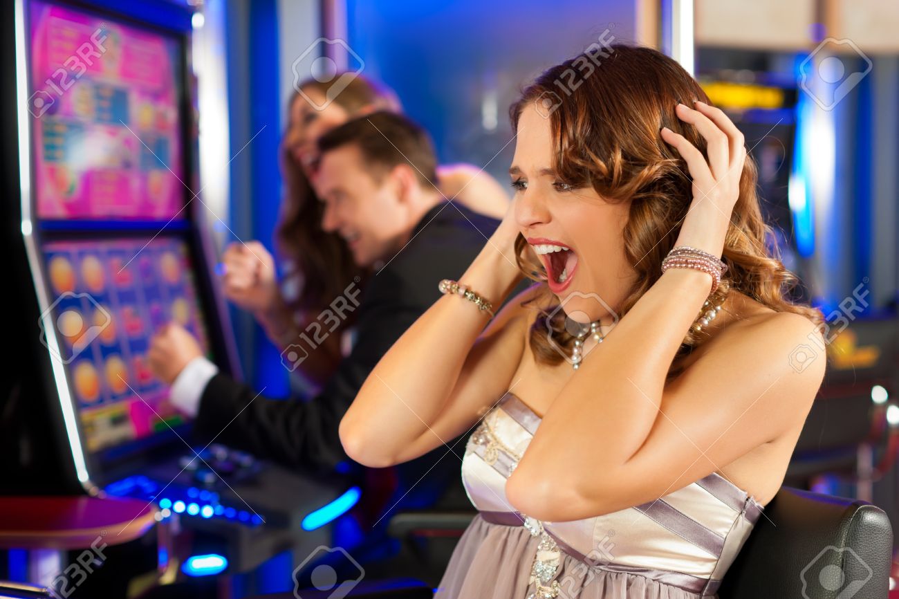 Friends In Casino On A Slot Machine; The Woman In Front Obviously Is Loosing Stock Photo, Picture And Royalty Free Image. Image 12443499.