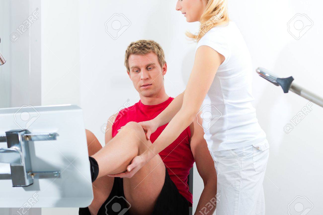 Patient at the physiotherapy making physical exercises with his therapist - 13452820 Patient at the physiotherapy making physical exercises with his therapist - 13452820