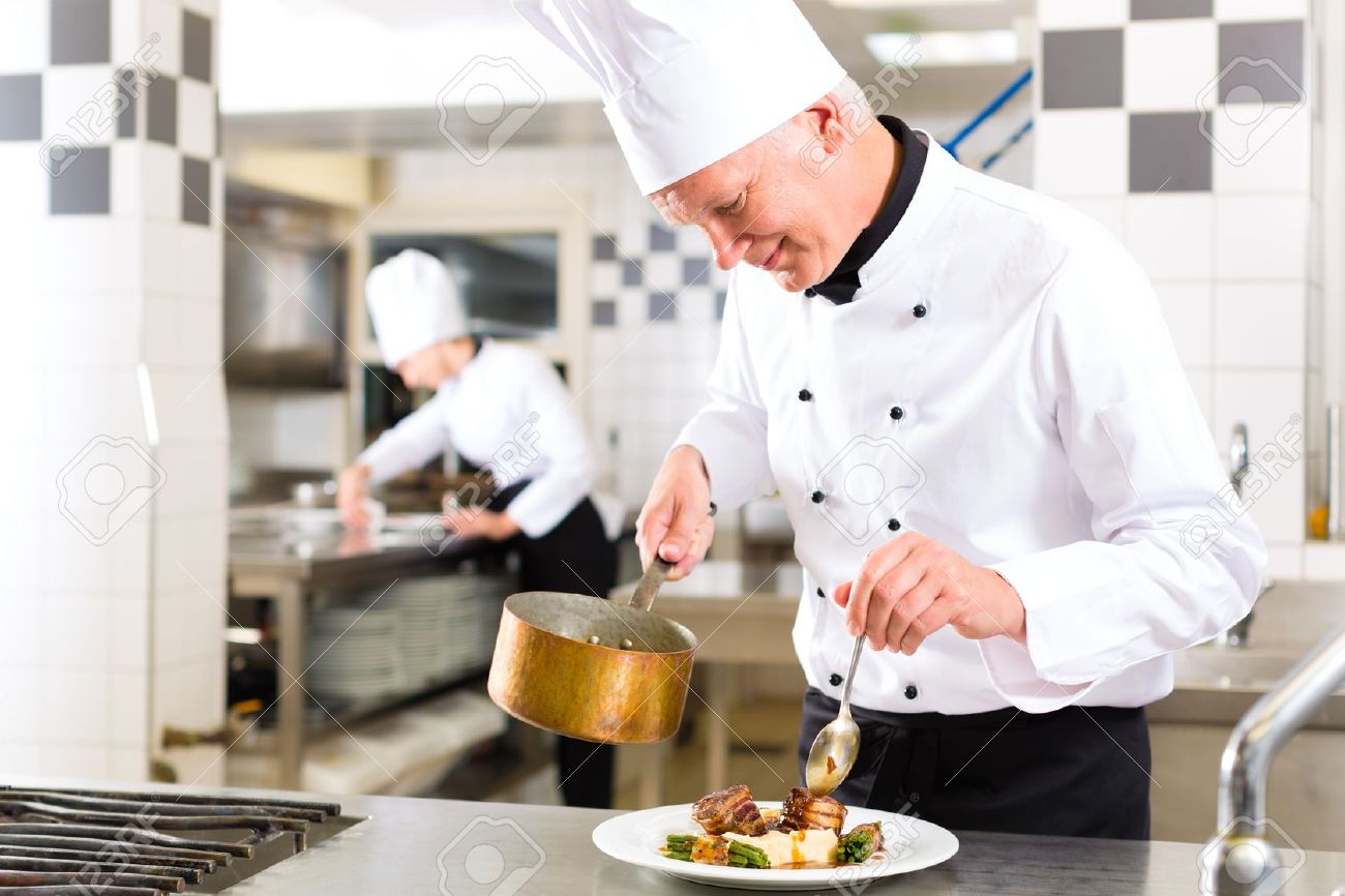 chef in hotel or restaurant kitchen cooking he is working on saucier chef