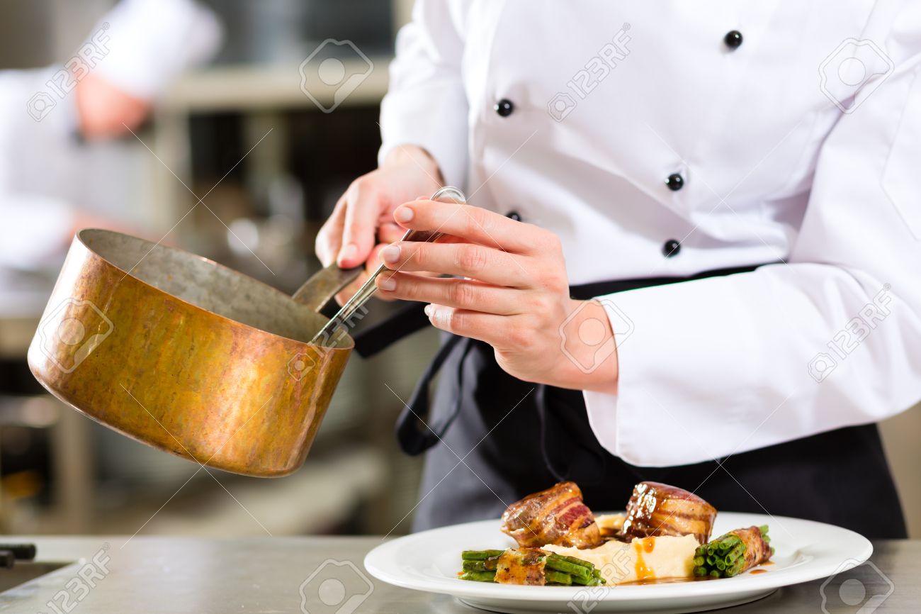 female chef in hotel or restaurant kitchen cooking only hands saucier chef