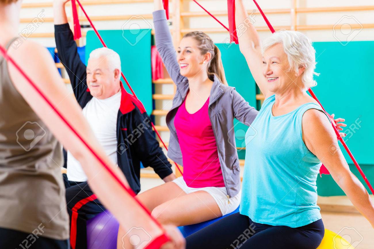 Senior people at fitness course in gym exercising with stretch band - 37922685 Senior people at fitness course in gym exercising with stretch band - 37922685