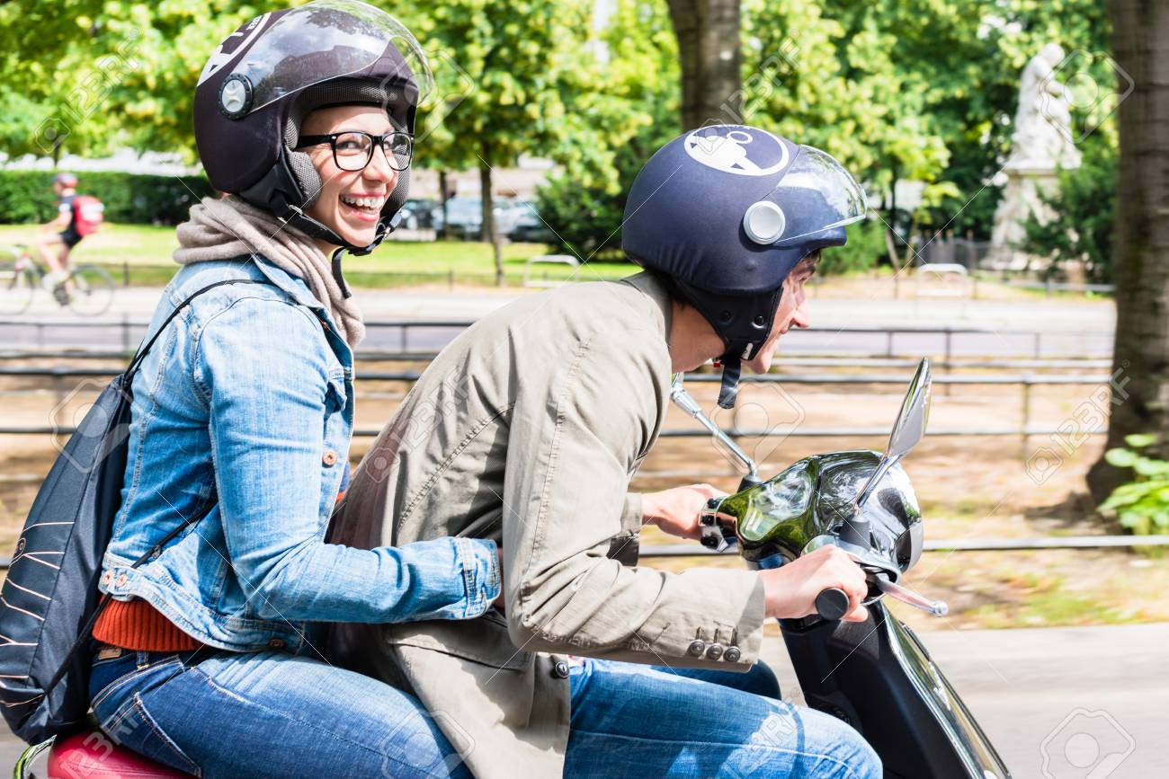 Mujer De La Moto En La Vespa Con El Casco Foto de archivo Mujer De La Moto En La Vespa Con El Casco Foto de archivo