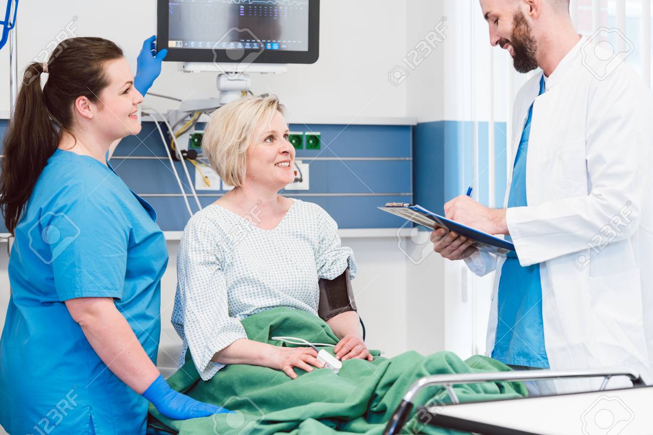 patient in recovery room of hospital talking to doctor and nurse recovery room nurse