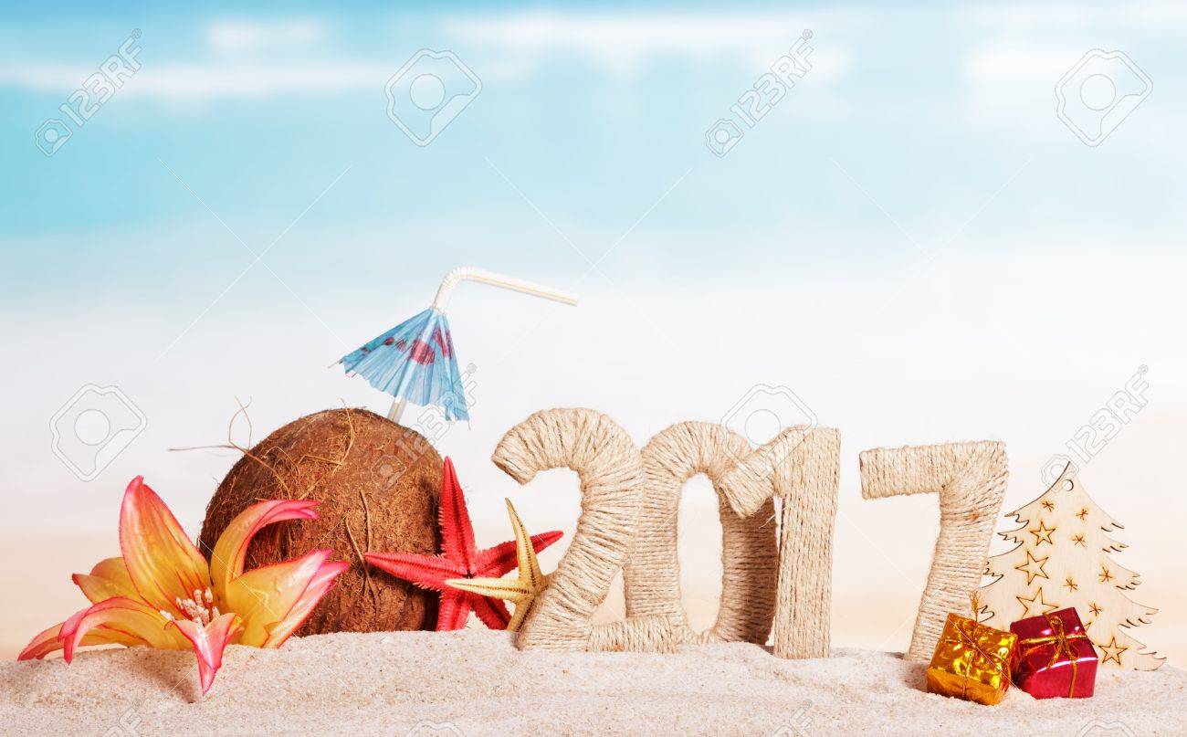Coconut, number 2017, starfish, flower, tree and Christmas presents in the sand against the sea. - 65487914 Coconut, number 2017, starfish, flower, tree and Christmas presents in the sand against the sea. - 65487914
