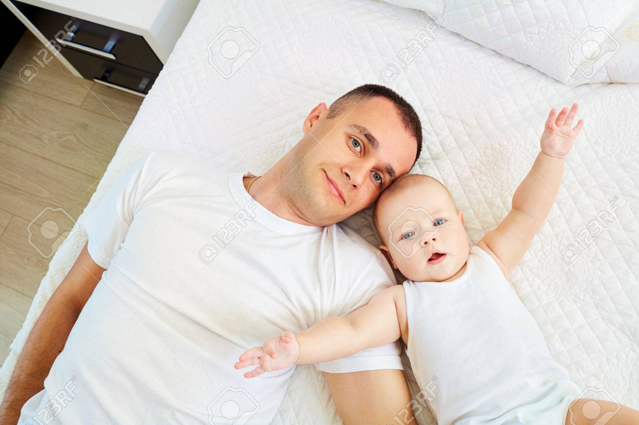 Vista Superior De Un Padre Y Un Bebe Papa E Hijo Bebe Acostado En Una Cama Blanca Fotos Retratos Imagenes Y Fotografia De Archivo Libres De Derecho Image