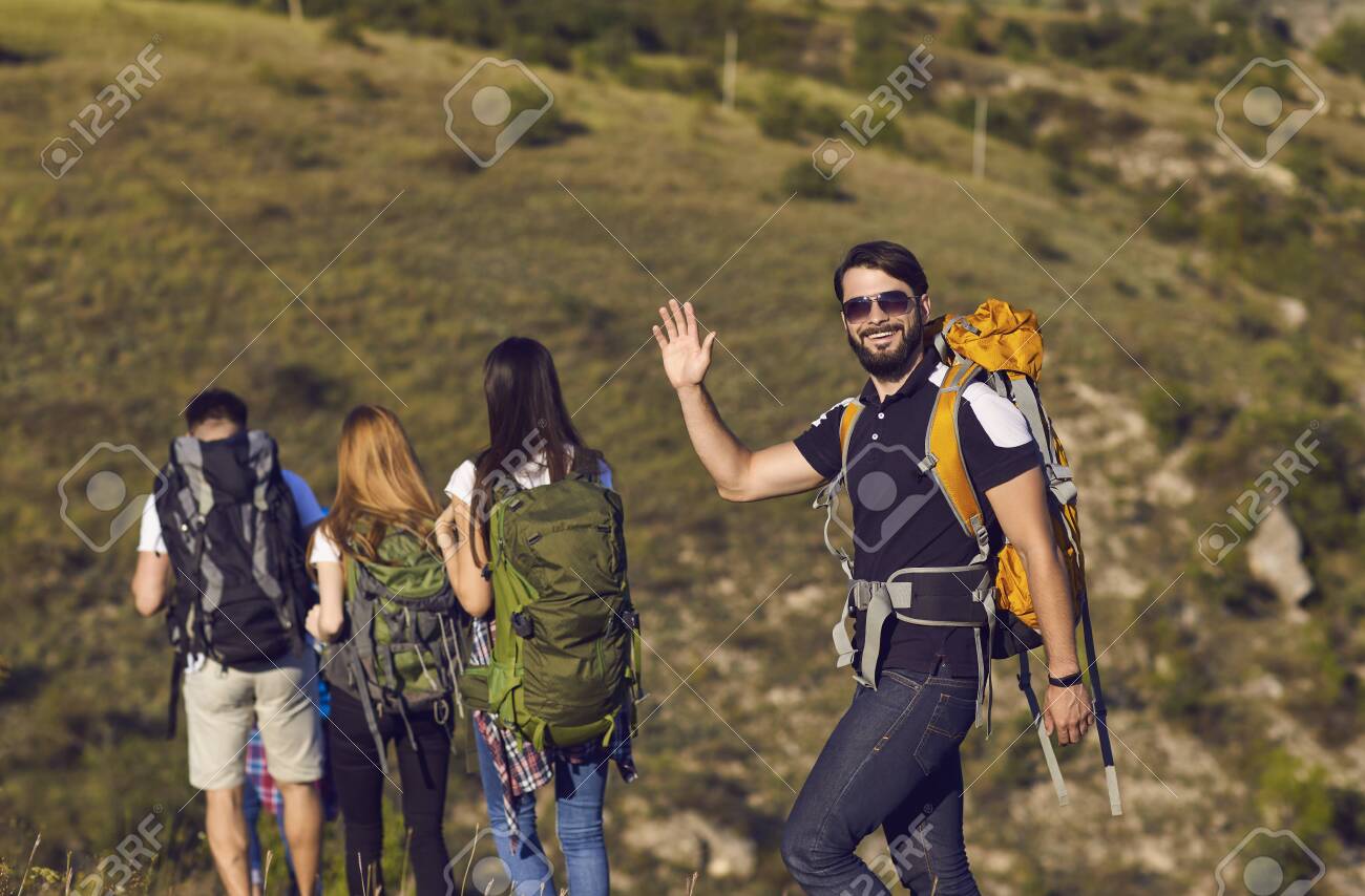 A group of hikers with backpacks are walking along the hill in the mountains in nature. Travel adventure people tourists. - 151965881 A group of hikers with backpacks are walking along the hill in the mountains in nature. Travel adventure people tourists. - 151965881