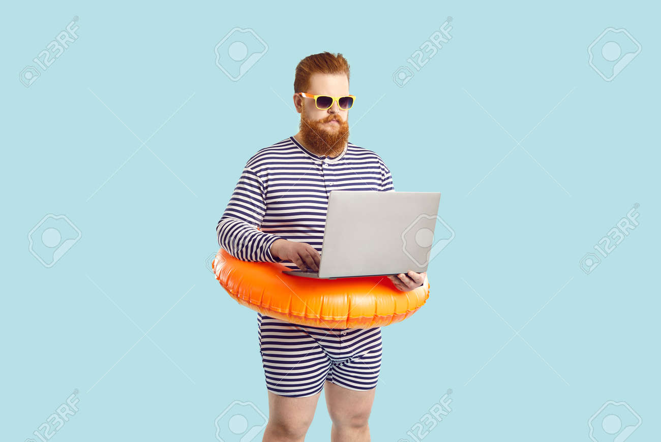 Funny Man Finds Time For Business During Summer Holiday At Seaside. Serious  Chubby Entrepreneur Working On Computer While On Vacation. Busy Plus Size  Guy In Striped Swimsuit Using His Laptop At Beach, image size:1300x870