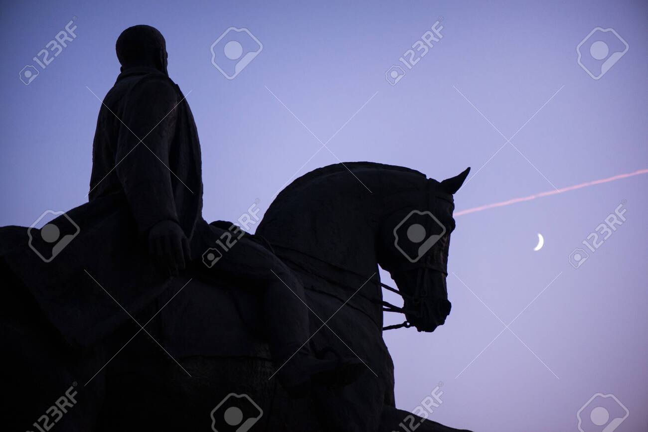 Abstract, blurry shot moon in focus. Statue of knight and horse riding towards victory. New moon and birds in the background of blue night sky - 119718499 Abstract, blurry shot moon in focus. Statue of knight and horse riding towards victory. New moon and birds in the background of blue night sky - 119718499