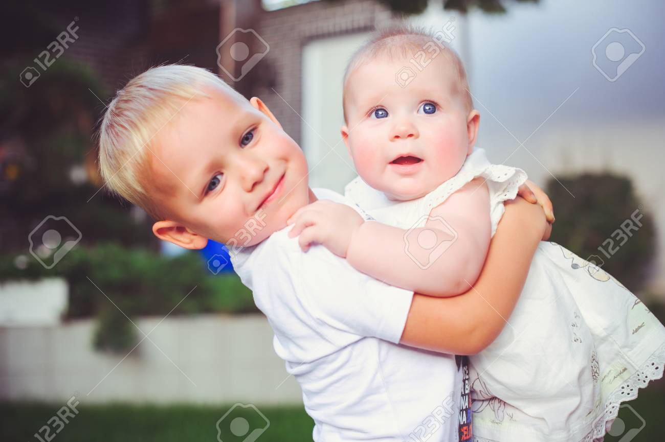 幸せな弟は 彼の妹の赤ちゃん 男の子と女の子を抱きしめる コンセプト愛と子育てを抱き合います の写真素材 画像素材 Image