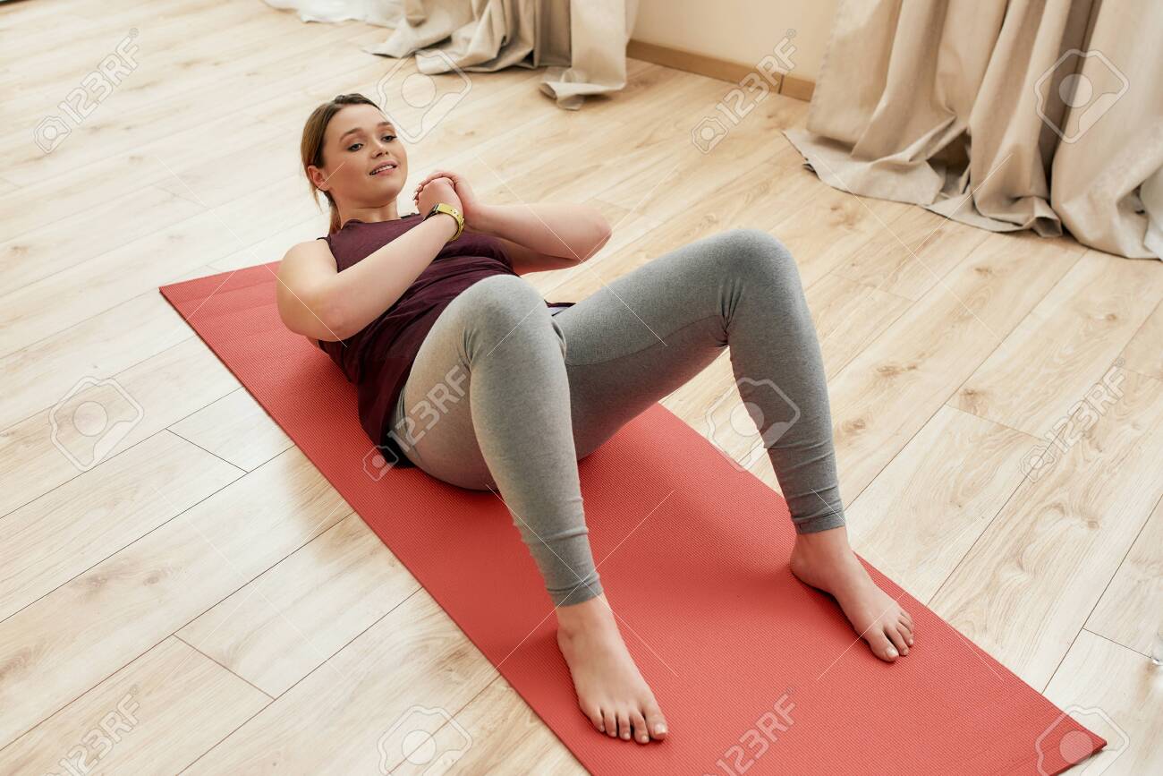 Begin To Act Young Curvy Woman In Sportswear Exercising On A Yoga Mat Doing Crunches At Home Lizenzfreie Fotos Bilder Und Stock Fotografie Image