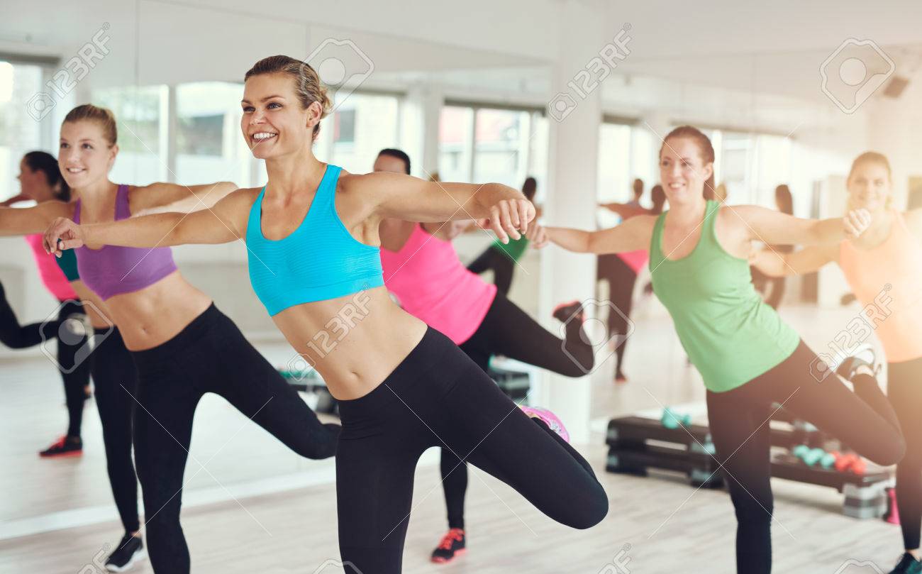 young women in colorful sportswear working out in aerobics class