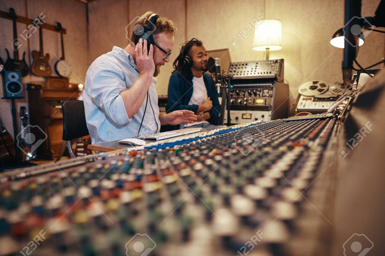 Music Producer Working On A Soundboard While Listening To A Young Stock Photo Picture And Royalty Free Image Image 122795795