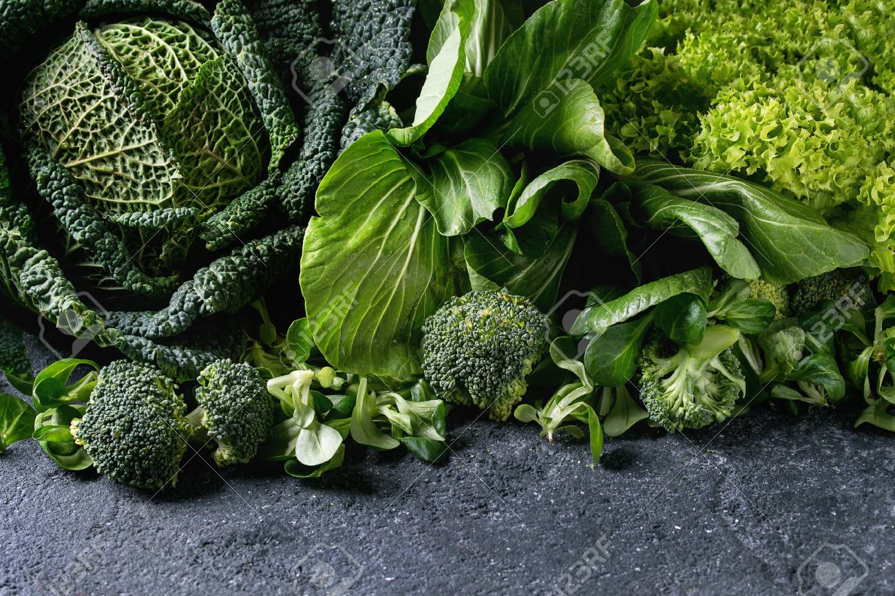 Variety of raw green vegetables salads, lettuce, bok choy, corn, broccoli, savoy cabbage as frame over black stone texture background. Space for text - 74385003 Variety of raw green vegetables salads, lettuce, bok choy, corn, broccoli, savoy cabbage as frame over black stone texture background. Space for text - 74385003