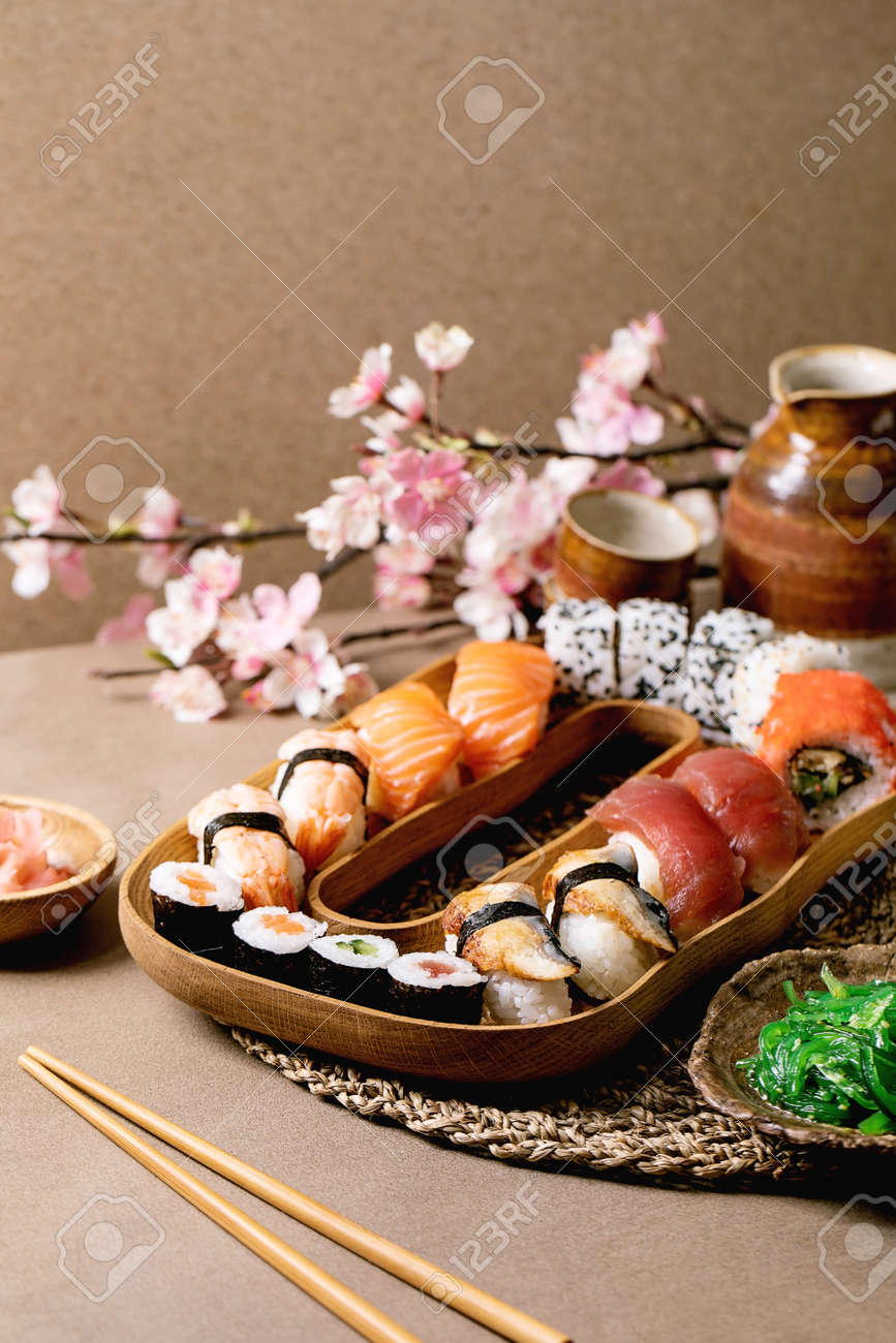 Ensemble de rouleaux de sushi. rouleaux de sushi japonais traditionnels avec du saumon frais, du thon, de l'anguille, des crevettes sur du riz. servir sur une assiette en bois avec sauce soja, salade wakame sur table brune. service à saké et fleurs printanières - 182579791 Ensemble de rouleaux de sushi. rouleaux de sushi japonais traditionnels avec du saumon frais, du thon, de l'anguille, des crevettes sur du riz. servir sur une assiette en bois avec sauce soja, salade wakame sur table brune. service à saké et fleurs printanières - 182579791