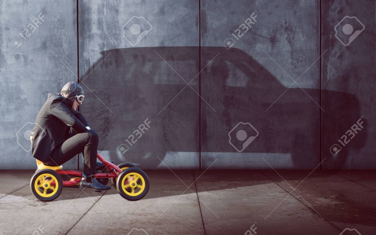 Ambitous Businessman on a pedal car - 76941227 Ambitous Businessman on a pedal car - 76941227