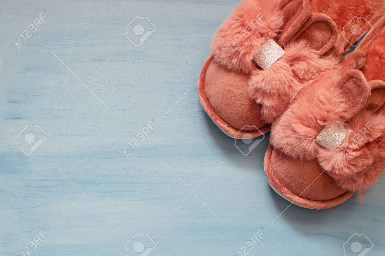 Cute Fluffy Slippers In The Shape Of A Bunny With Ears On A Blue