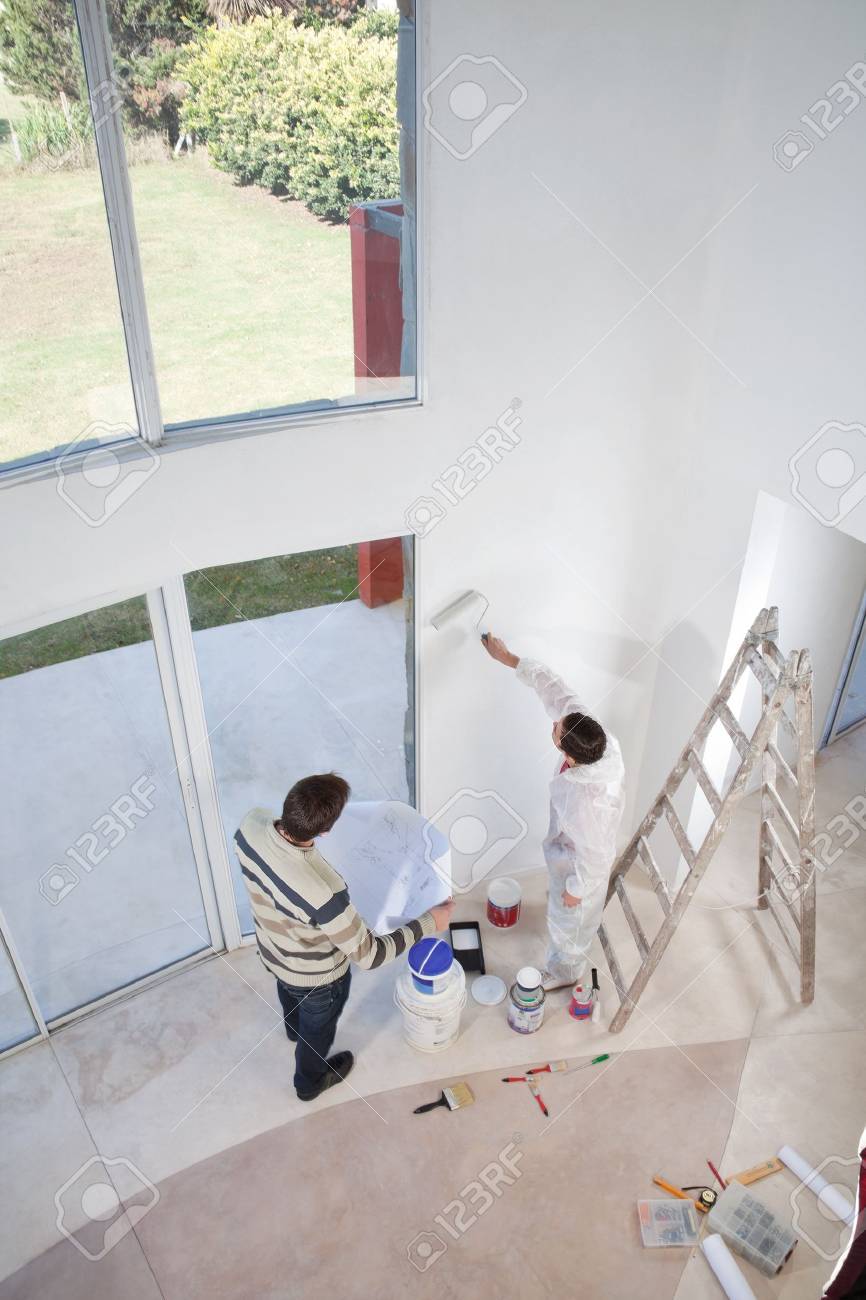 Blueprint Interior Design Painting high angle view of man holding blueprint and workman painting Blueprint Interior Design Painting high angle view of man holding blueprint and workman painting