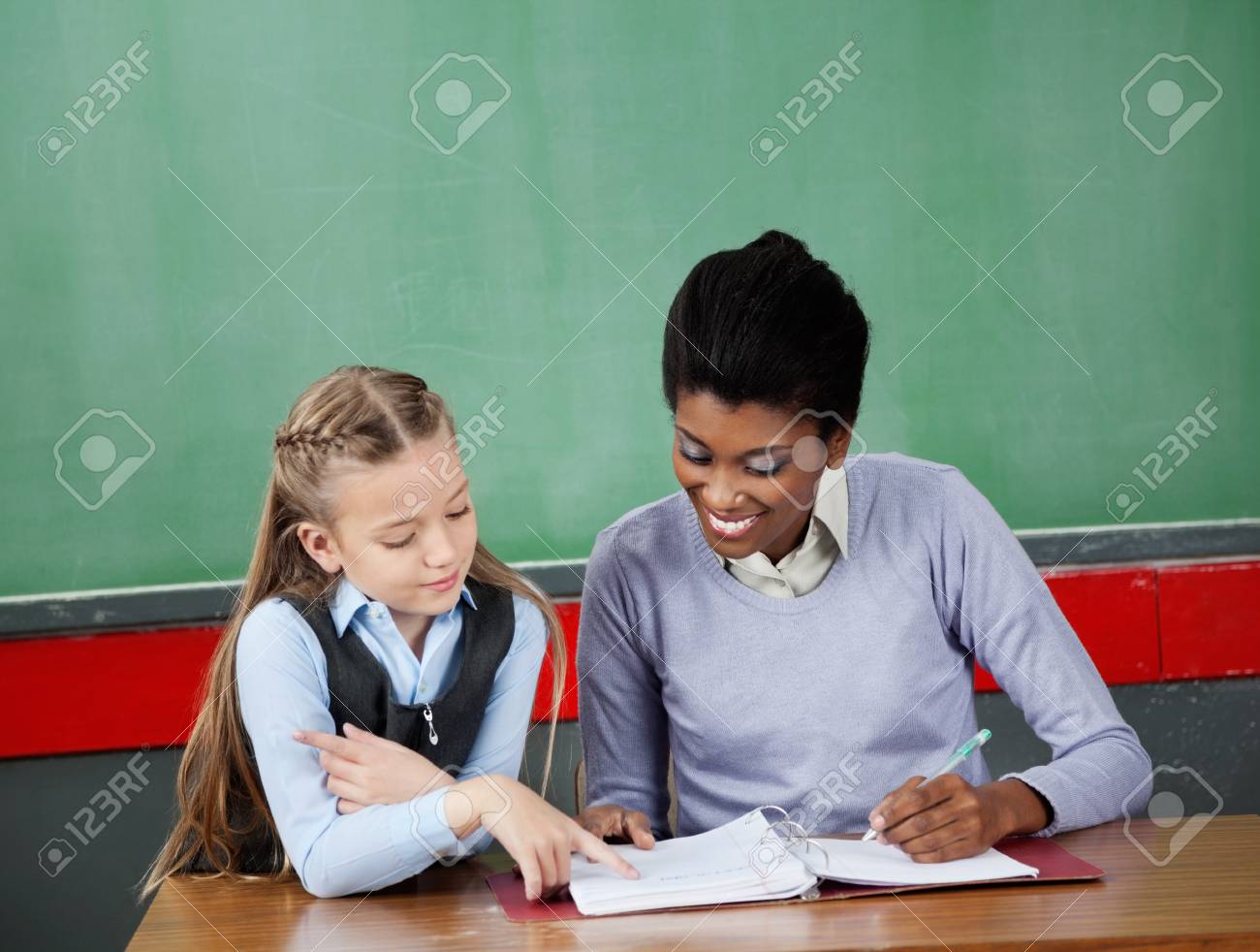 Schoolgirl Asking Question To Teacher At Desk Stock Photo 20198996 Schoolgirl Asking Question To Teacher At Desk Stock Photo 20198996