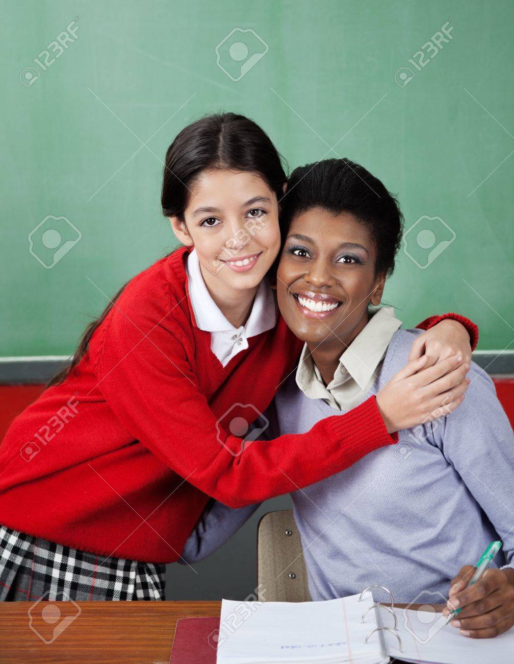 Schoolgirl Hugging Female Teacher At Desk Stock Photo 20591816 Schoolgirl Hugging Female Teacher At Desk Stock Photo 20591816