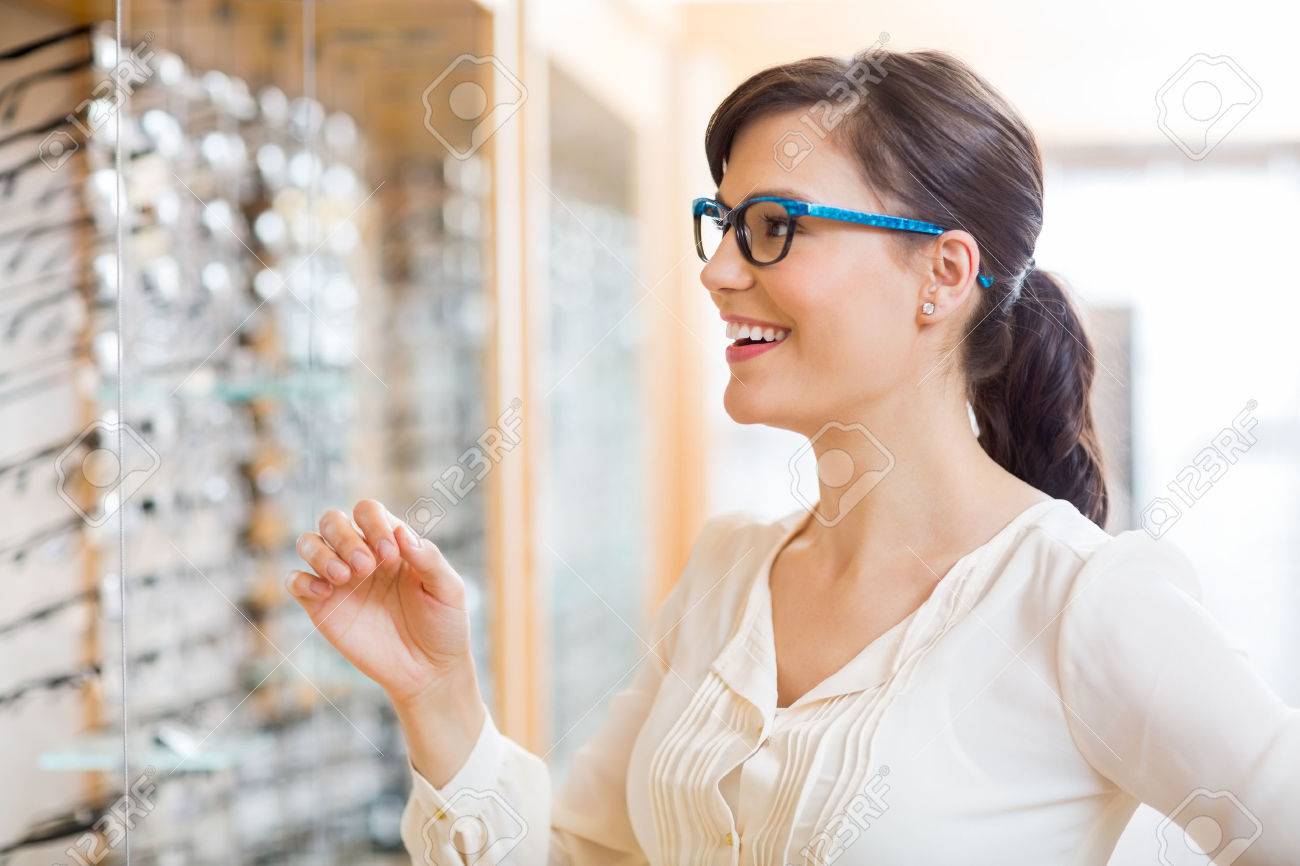 眼鏡店で新しいメガネをしようとしている幸せな若い女 の写真素材 画像素材 Image