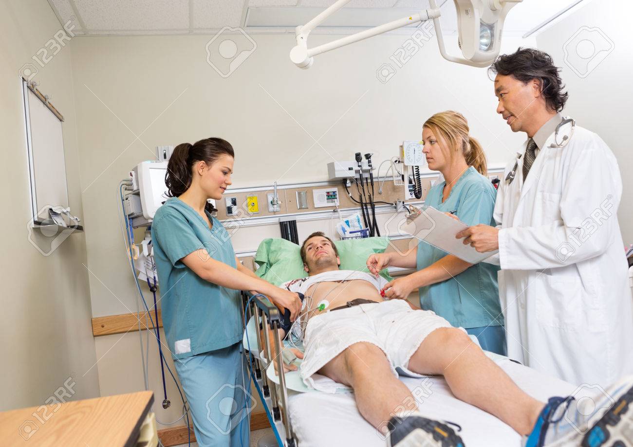 Multiethnic doctor and nurses checking patient in hospital - 23743497 Multiethnic doctor and nurses checking patient in hospital - 23743497