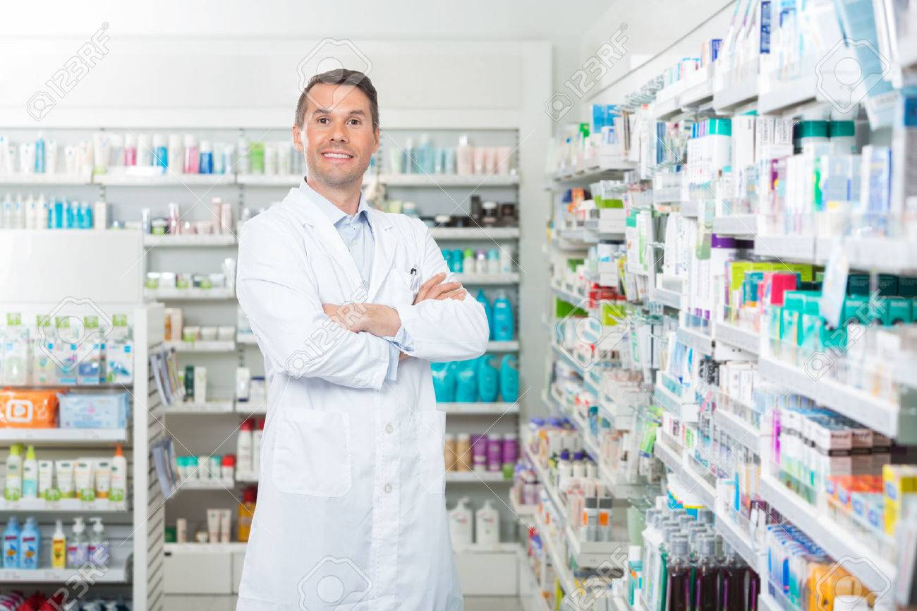 Portrait of smiling mid adult male pharmacist standing arms crossed in pharmacy - 43661132 Portrait of smiling mid adult male pharmacist standing arms crossed in pharmacy - 43661132