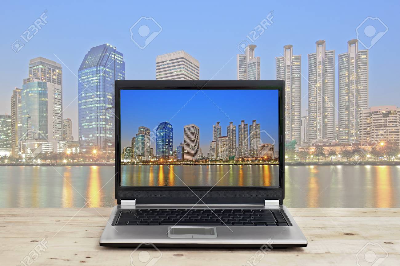ビジネス コンセプト考え 景観は 高層ビルの背景に木製のテーブルの上のノート パソコン の写真素材 画像素材 Image