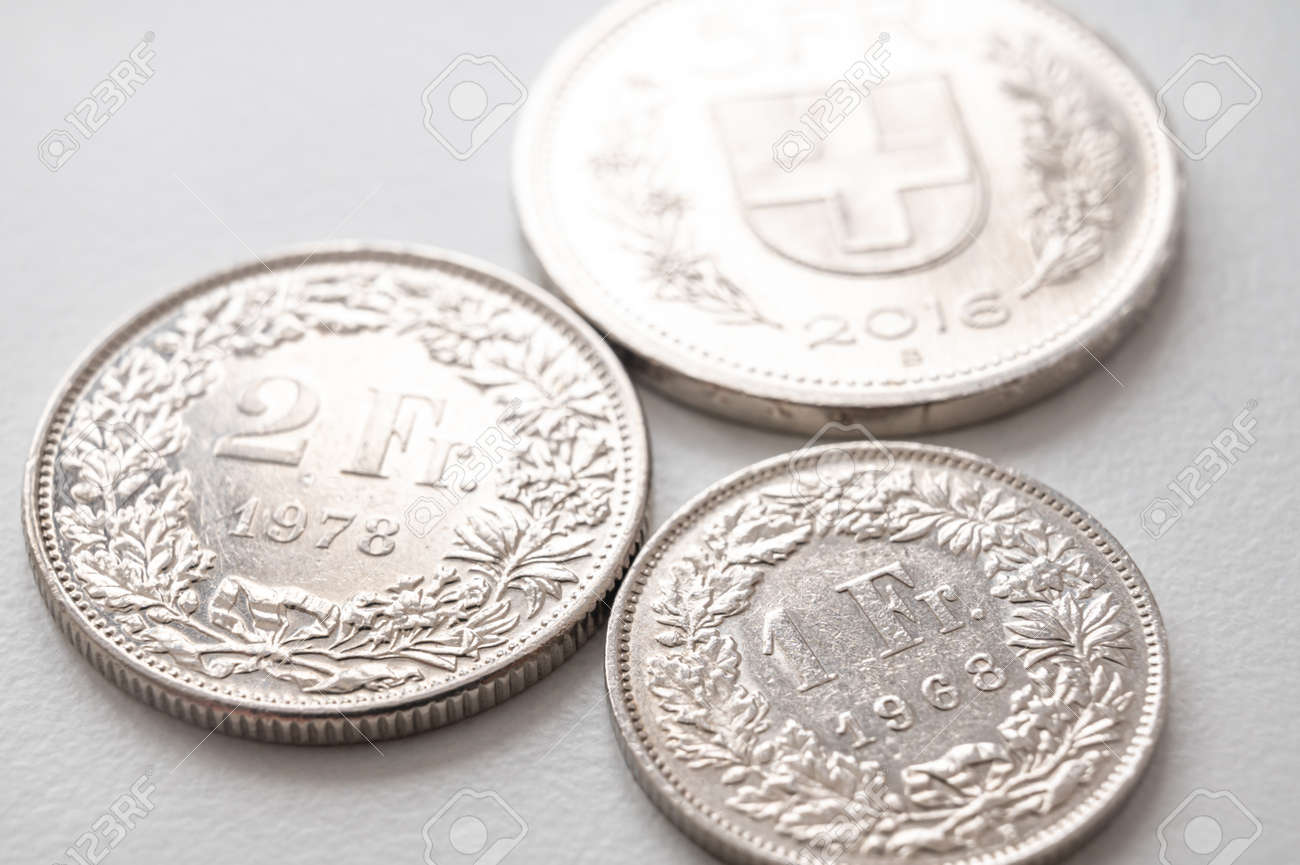 白い表面にスイスフランの硬貨。スイスフランの価値と為替レートの傾向。の写真素材・画像素材 Image 183514476
