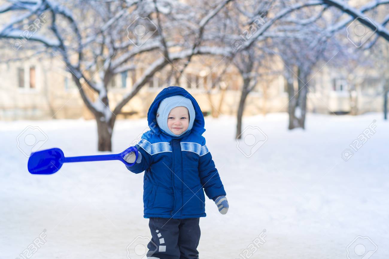 Cute Baby Boy Playing With Snow Toy Shovel In Winter Outdoor Stock