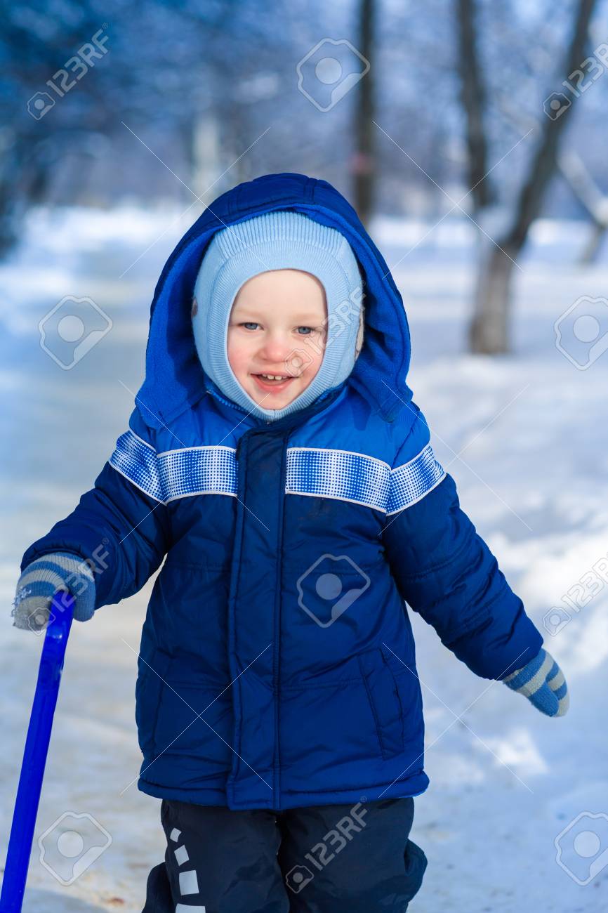 Cute Baby Boy Playing With Snow Toy Shovel In Winter Outdoor Stock