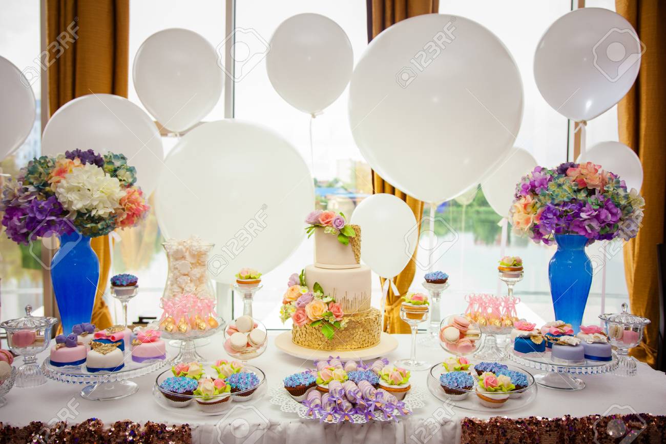Candy bar on golden wedding party with a lot of different candies, cupcakes, souffle and cakes. Decorated in brown and purple colors, nature and eco theme, indoor. - 120314888 Candy bar on golden wedding party with a lot of different candies, cupcakes, souffle and cakes. Decorated in brown and purple colors, nature and eco theme, indoor. - 120314888