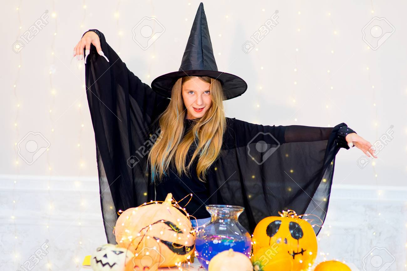 魔女の衣装ハロウィーン パーティー中にカボチャと青ポーションのボトルでポーズのティーンエイ ジャーの女の子 の写真素材 画像素材 Image