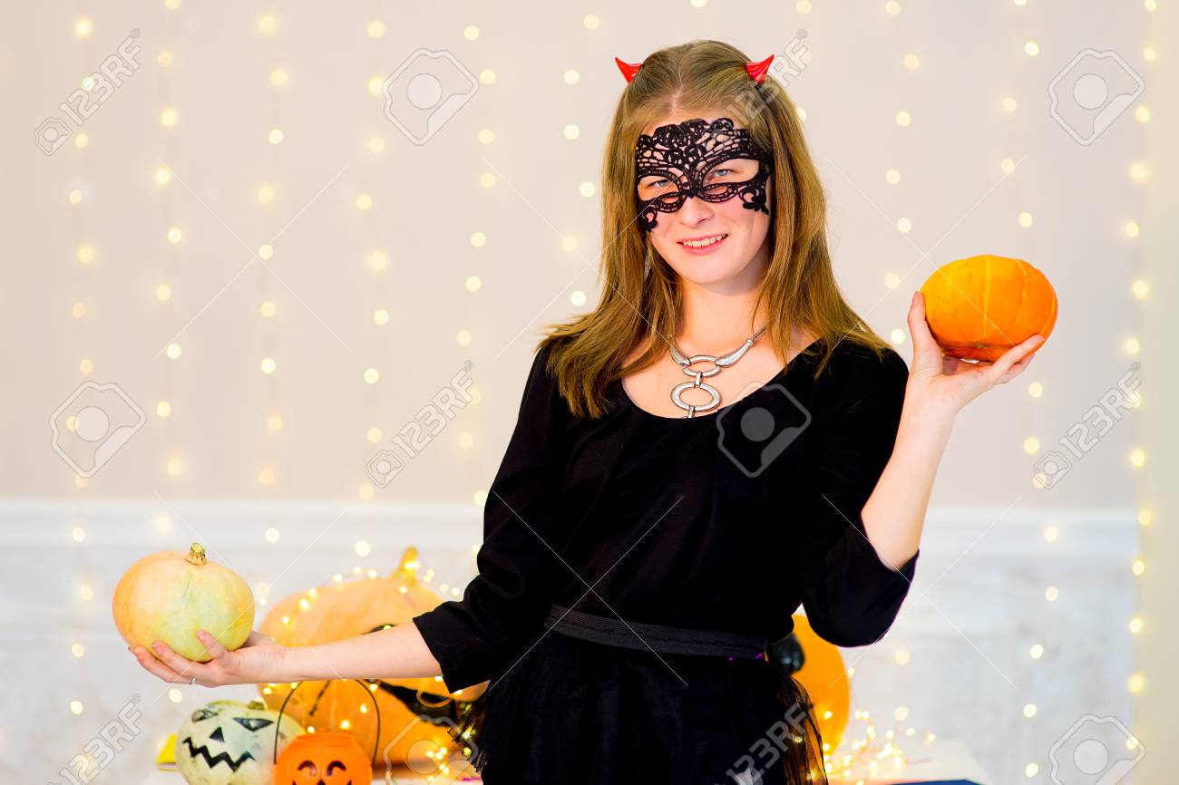 悪魔コスチューム ハロウィーン パーティー中にカボチャと青ポーションのボトルでポーズのティーンエイ ジャーの女の子 の写真素材 画像素材 Image