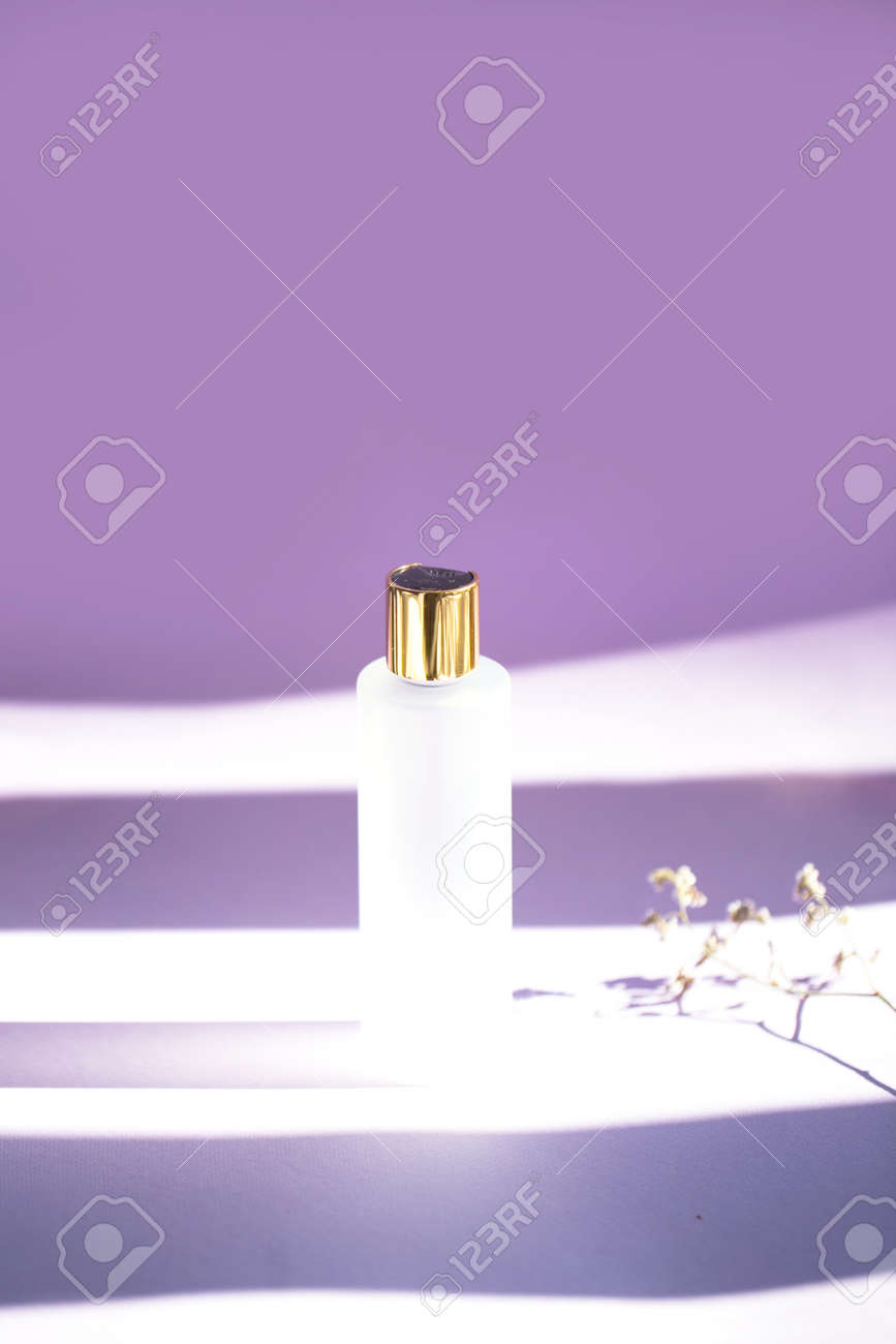 Download Matte Cosmetic Bottle With Golden Cap On The Purple Background Stock Photo Picture And Royalty Free Image Image 155581730
