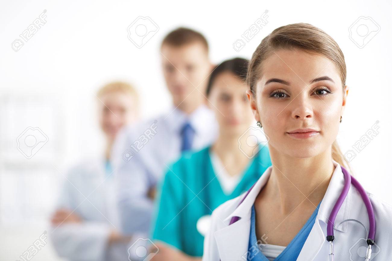 Attractive female doctor in front of medical group . - 43526857 Attractive female doctor in front of medical group . - 43526857