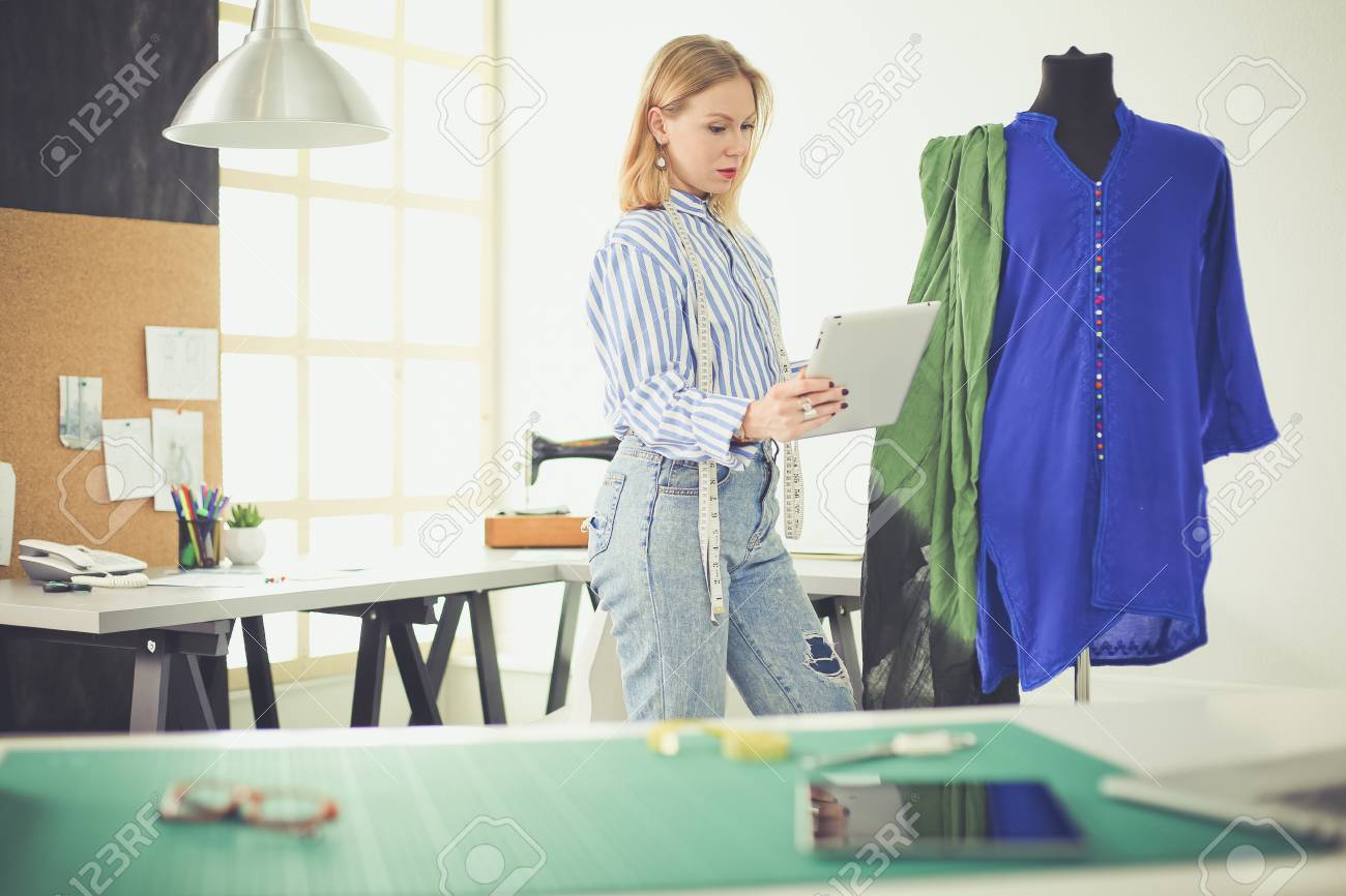 Fashion designer working on her designs in the studio - 101840161 Fashion designer working on her designs in the studio - 101840161