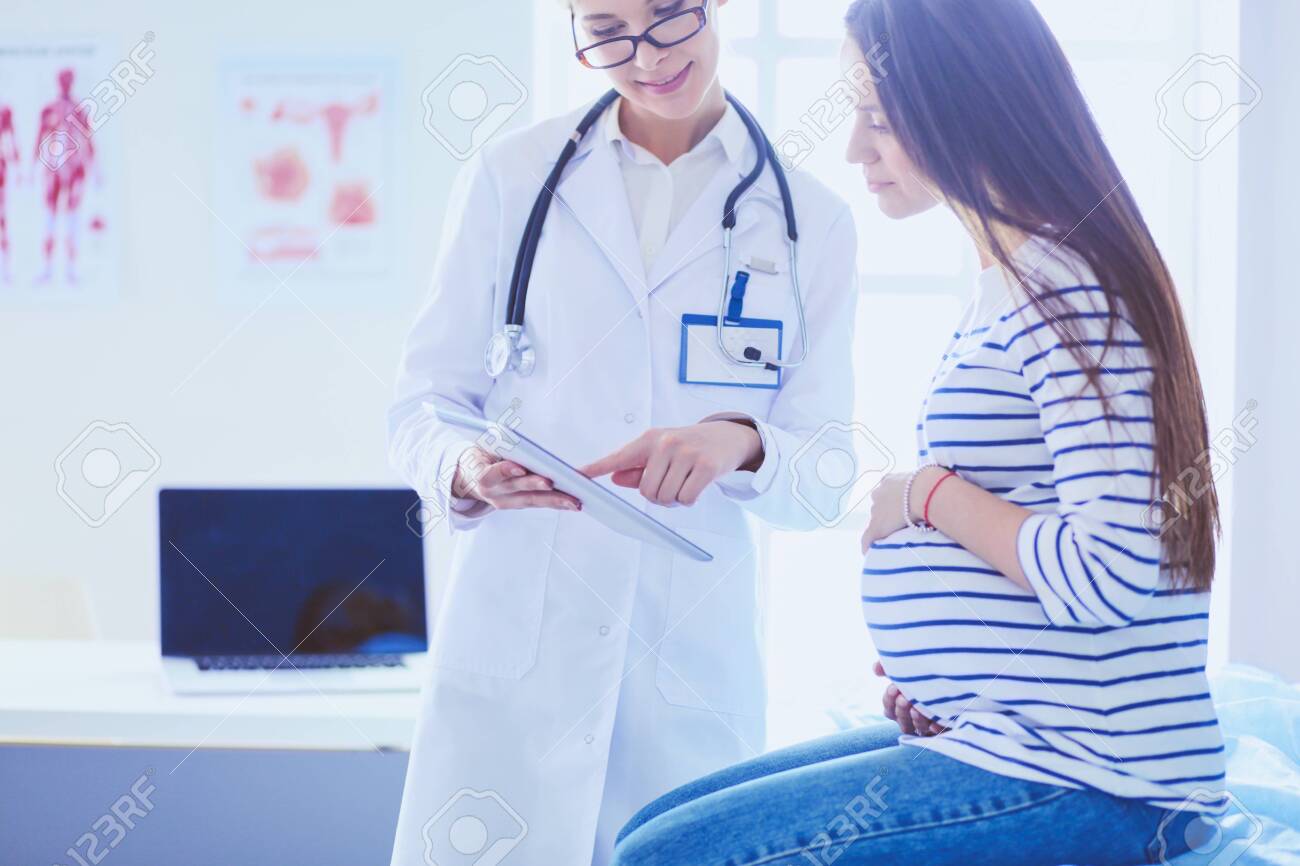 Beautiful smiling pregnant woman with the doctor at hospital - 115486621 Beautiful smiling pregnant woman with the doctor at hospital - 115486621