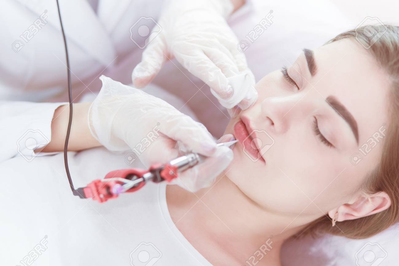 A young girl having red lips permanent makeup, micropigmentation - 122798289 A young girl having red lips permanent makeup, micropigmentation - 122798289