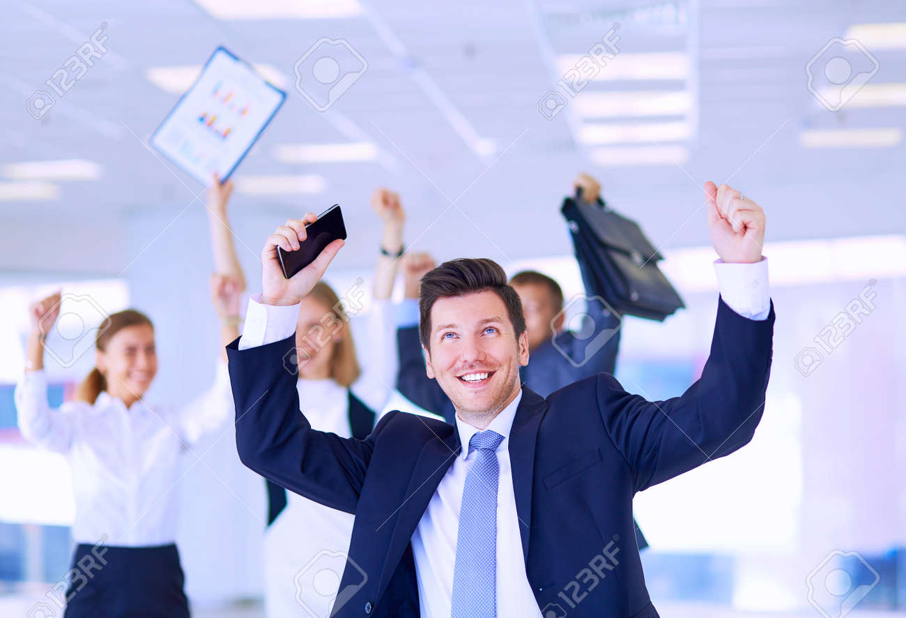 Business team celebrating a triumph with arms up - 155704230 Business team celebrating a triumph with arms up - 155704230