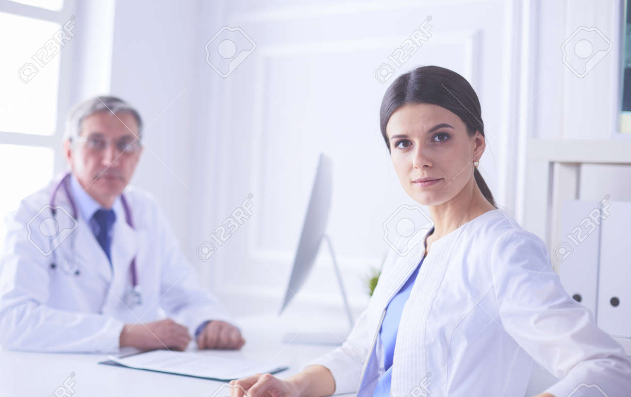 Two doctors smiling in consulting room in hospital - 169252699 Two doctors smiling in consulting room in hospital - 169252699