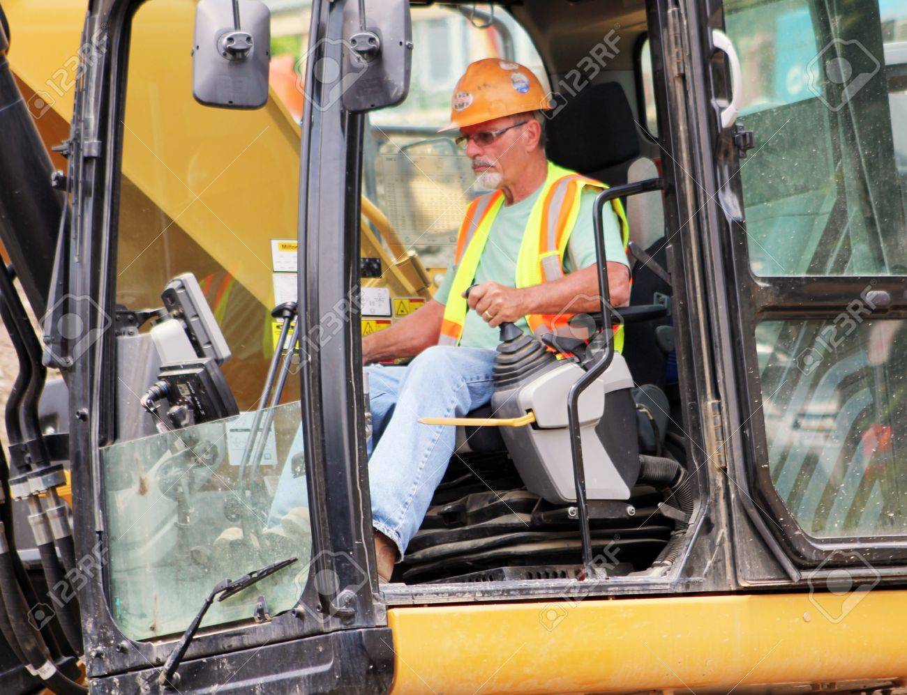 a front end loader heavy equipment operator in the cab of his heavy machine operator